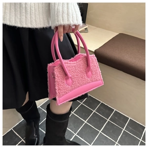 Detailed view of pink plush crossbody bag with furry texture and leather trim
