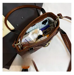 Macro view of brown leather bag interior showing spacious storage and plush charm