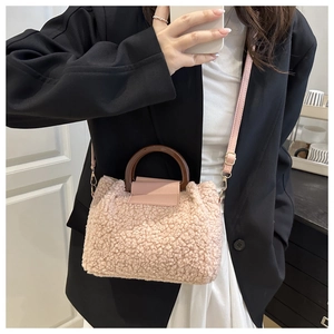 Détail du sac à main rose en fausse fourrure avec poignée ronde en bois et bandoulière