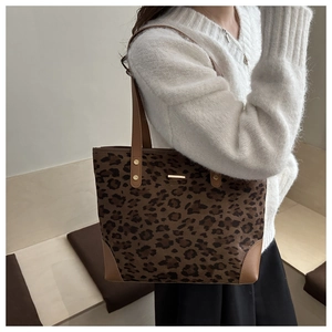 Leopard print tote bag with brown leather straps and gold metal accent detail