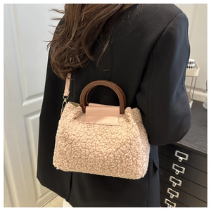 Detailansicht der flauschigen Lammfell-Handtasche mit Holzgriffen und rosa Lederakzenten