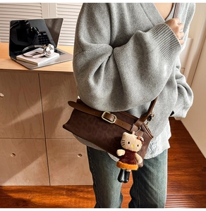 Close-up of leopard print shoulder bag with a cute character plush pendant
