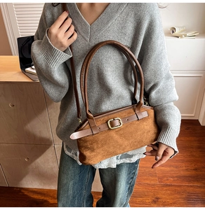 Brown vintage suede handbag styled with a grey knit sweater and blue jeans