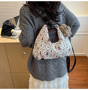 Quilted beige tote bag with cute animal charms and leather straps in a home office setting