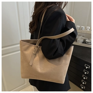 Detail of adjustable shoulder strap and khaki suede texture on a minimalist tote bag