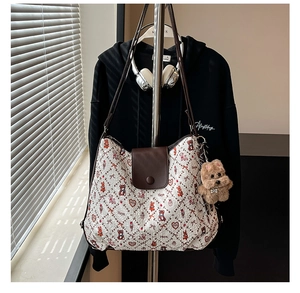 Detail of vintage tote bag featuring animal prints and a cute plush puppy pendant
