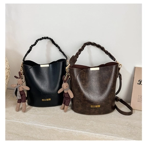 Close-up of vintage bucket bags in black and brown with woven handles and bunny charms