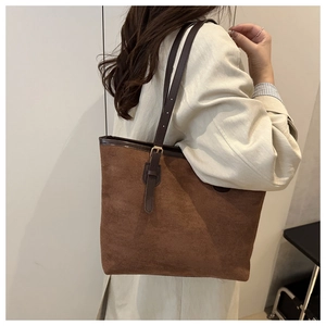 Detailed close-up of dark brown suede tote bag featuring adjustable golden metal buckle