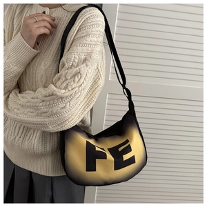 Detail of gradient crossbody bag with FE letter print worn with a beige sweater