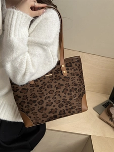 Fashionable leopard print tote bag with brown leather trim and gold metal hardware detail