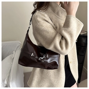 Close-up of dark brown leather dumpling bag with silver hardware and chic shoulder strap