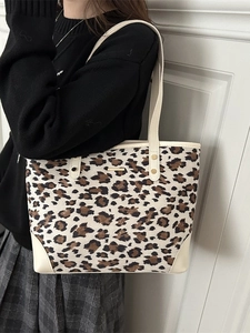 Chic leopard print canvas tote bag with cream leather handles and gold metal detail