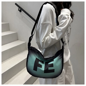 Close-up of a gradient green crossbody bag with a bold FE letter print and nylon texture