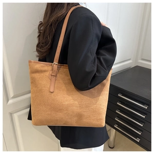 Détail du cabas en daim fauve avec bretelles réglables en cuir et boucle métallique