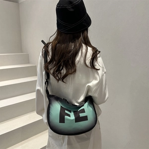 Detail of trendy crescent moon crossbody bag with FE logo and gradient mint finish