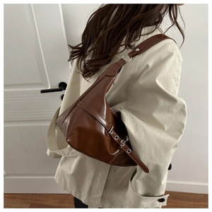 Detail of vintage brown leather shoulder bag with silver metallic buckle and eyelets