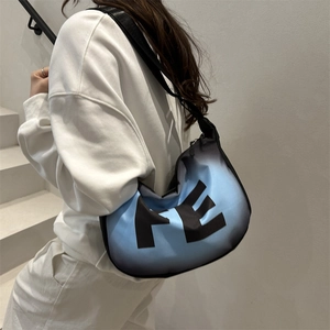 Detail showing gradient blue crescent crossbody bag with large FE logo and wide strap