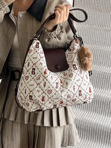 Vintage tote bag with bear print and plush charm shown in a high-fashion lifestyle pose