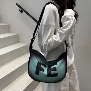 Black and green gradient crossbody bag with large FE letters on minimalist white stairs