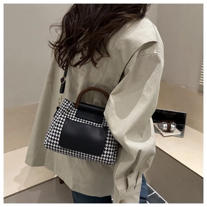 Détail du sac bandoulière pied-de-poule avec poignée en bois vintage et finitions en cuir