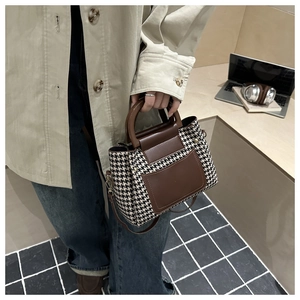 Détails du motif pied-de-poule contrasté et des coutures en cuir marron sur le petit sac