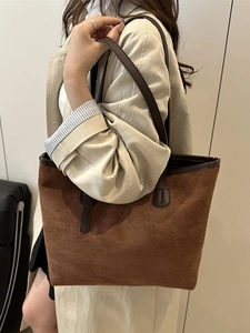 Brown suede tote bag with leather straps shown on shoulder for daily commute