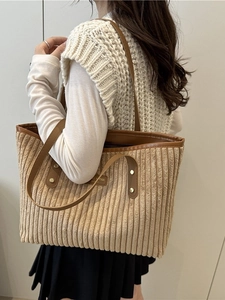 Grand sac cabas en velours côtelé beige avec anses en cuir marron porté à l'épaule