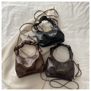 Close-up of three pleated leather cloud bags in black, coffee, and caramel colors
