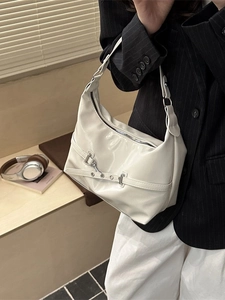 Chic cream glossy hobo bag with adjustable metallic buckle strap shown in a modern interior