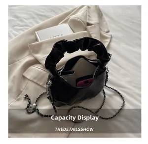 Detail view of the black pleated handbag interior showing phone and card wallet storage