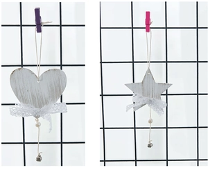 Close-up of wooden heart and star ornaments with white lace bows and tiny bells