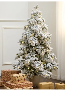 Detail of 135cm snowy PE Christmas tree with warm lights and grey base pot in home setting