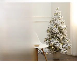 Detail of frosted needles with warm LED lights on a 135cm snowy Christmas tree in pot