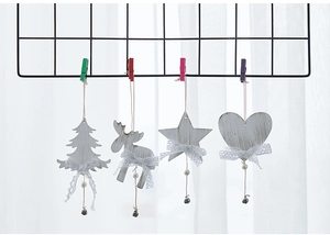 Detail of wooden Christmas ornaments with white lace bows and bells on a metal grid