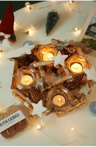 Close-up of birch wood candle holder with pine cones and four glass tea light cups