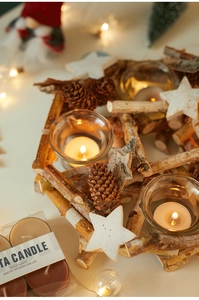 Detail of wooden Christmas candle holder with birch sticks, pine cones and tea candles
