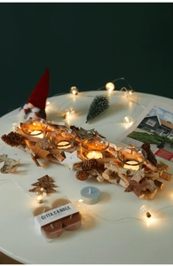Detail of wooden candle holder with pine cones and glass tea light cups for Christmas decor