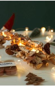 Detail of Nordic birch wood candle holder with pine cones and glass tea light cups