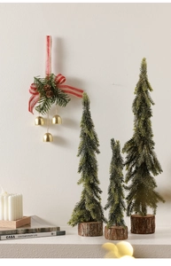 Detailed view of mini artificial pine trees with wooden bases and festive pine needle wreath