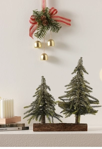 Dual miniature artificial Christmas pine trees on a rustic wooden base for table decor