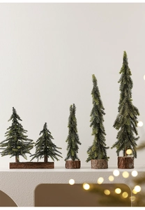Detail of five miniature artificial Christmas trees with natural wood bases in different sizes