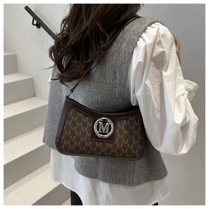 Detail of vintage baguette bag with brown letter print and metallic M logo clasp