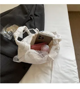 Spacious interior of white lace tote bag containing smartphone, wallet and skincare