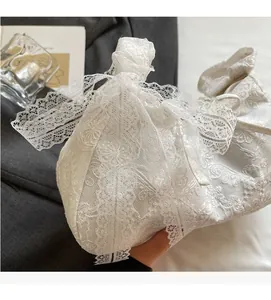 Detail view of intricate floral lace texture and scalloped edges on a white tote bag