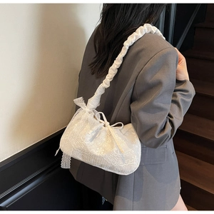 Detailed side view of white floral lace tote bag featuring elegant bow and ruffled strap
