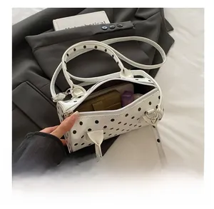 Internal capacity of polka dot Boston bag showing phone, wallet and cosmetics inside