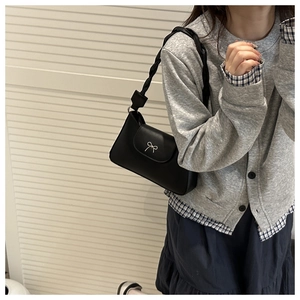 Detailed close-up of a black vintage crossbody bag featuring a silver metal bow accent