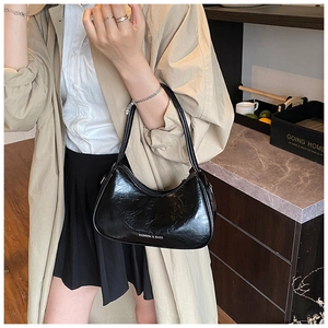 Détail du sac hobo noir brillant avec imprimé et finition en cuir verni texturé