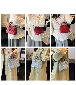 Detailed view of red and silver shell-shaped handbags with embossed checkered patterns