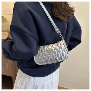 Close-up of quilted silver crossbody bag with crystal star and rhinestone stud details